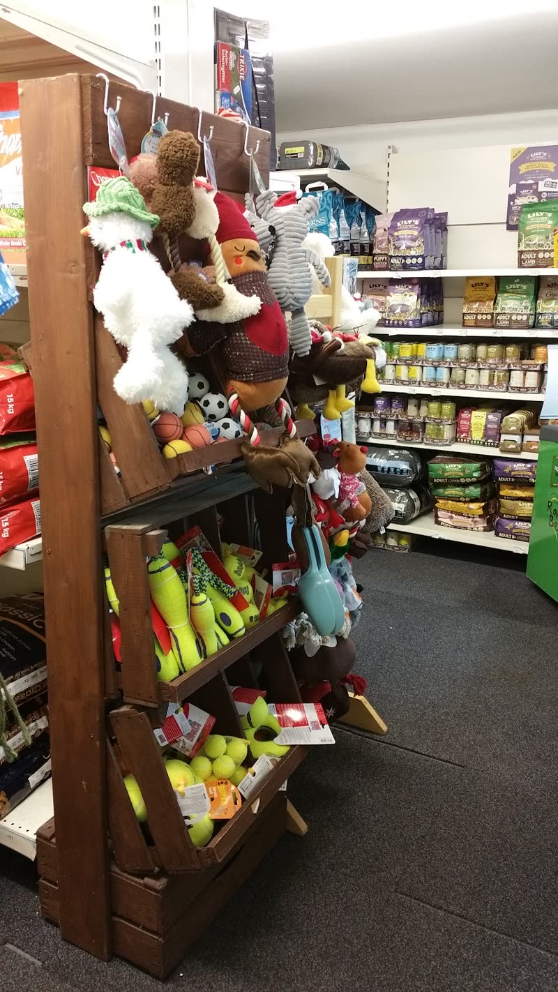 Shelves of dog toys, hanging squeaky plush toys and bags of pet food inside the shop